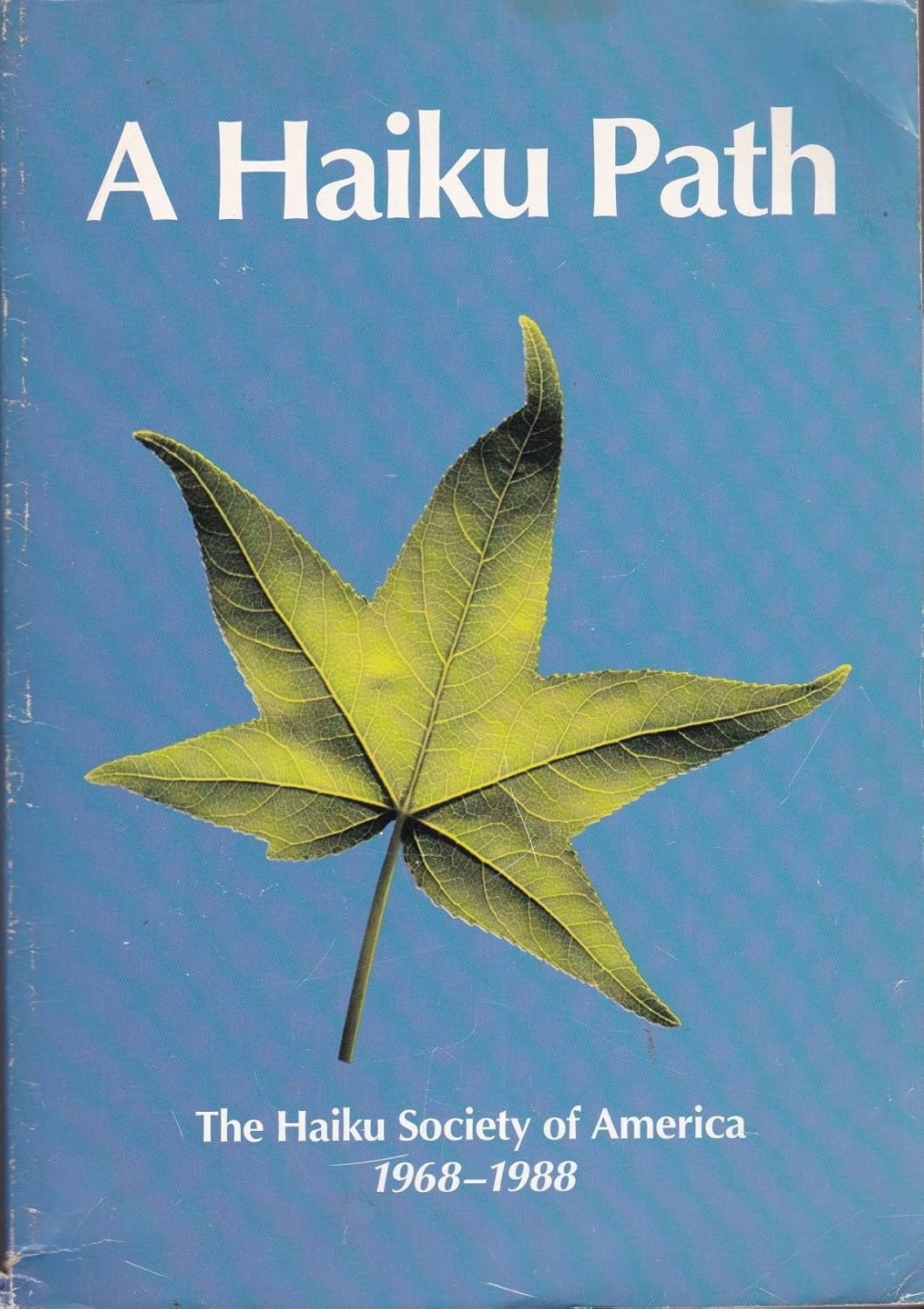 book cover of a A Haiku Path showing a vivid green leaf on a blue background